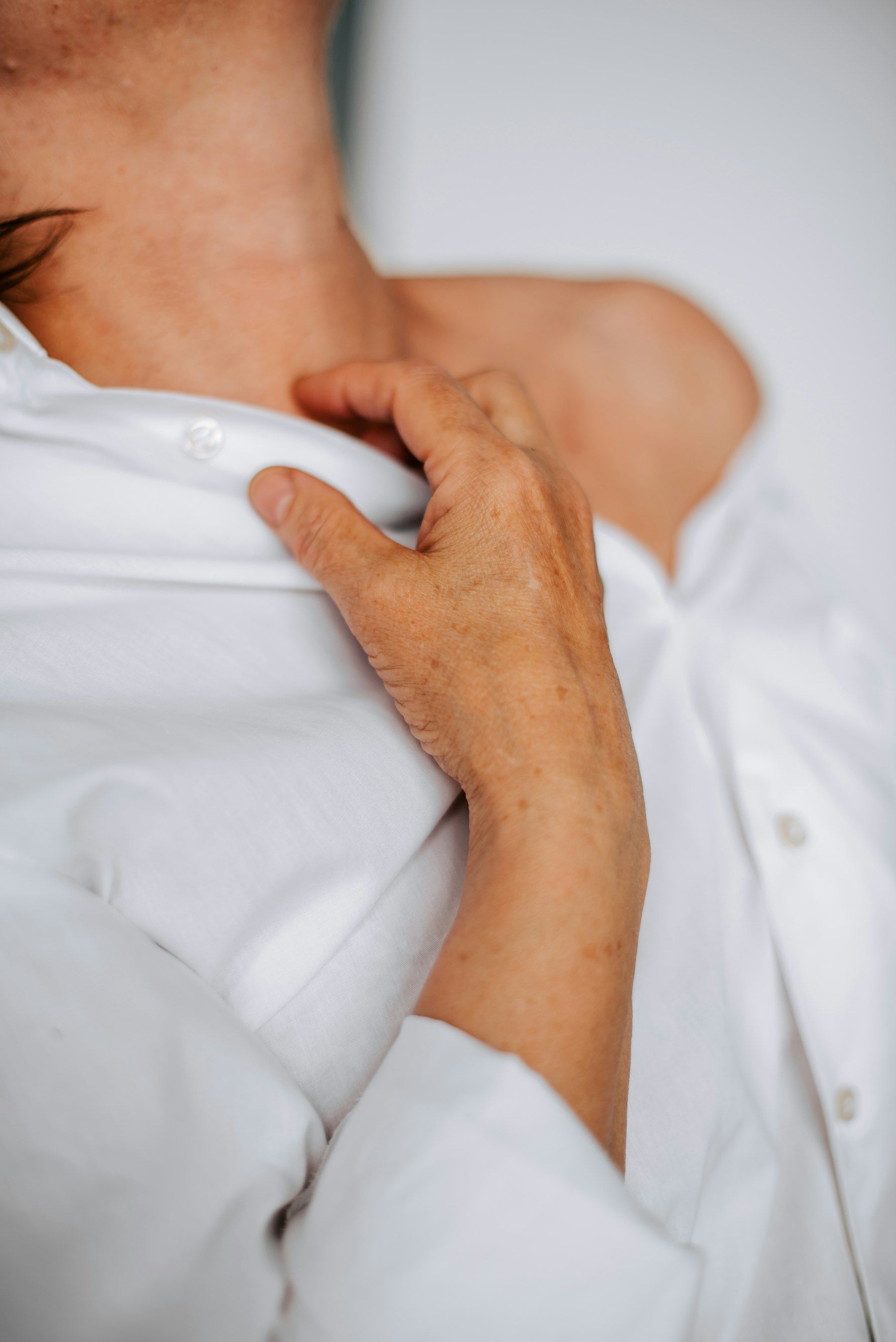 An older hand rests on a shoulder
